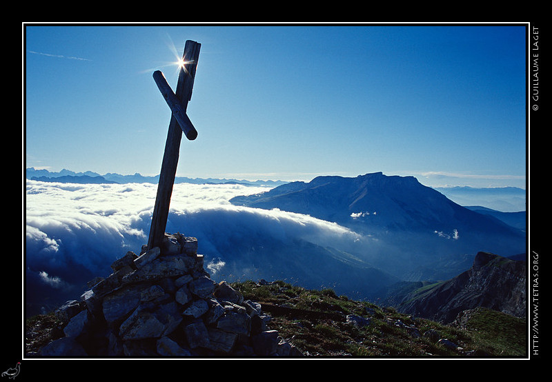 Dévoluy : La croix au sommet de la Tête de Garnesier. Une mer de nuages sous le plateau de Bure 
vient disparaître au col du Festre
