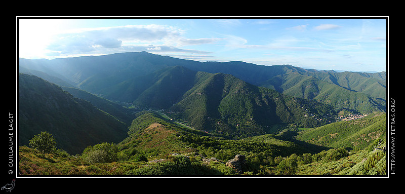 Photo :  Cette vue panoramique présente la haute vallée de l'Hérault. Sur ses premiers kilomètres, le petit fleuve coule depuis des cascades à gauche jusqu'au village de Valleraugue, à droite de l'image. Au centre de l'image, l'itinéraire des 